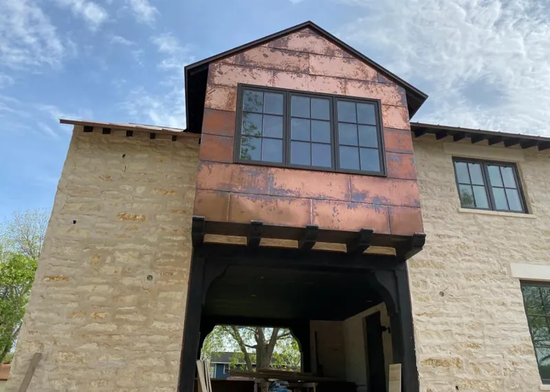 Copper metal panel facade on a stone building for Metal Roof Coating in Stratham
